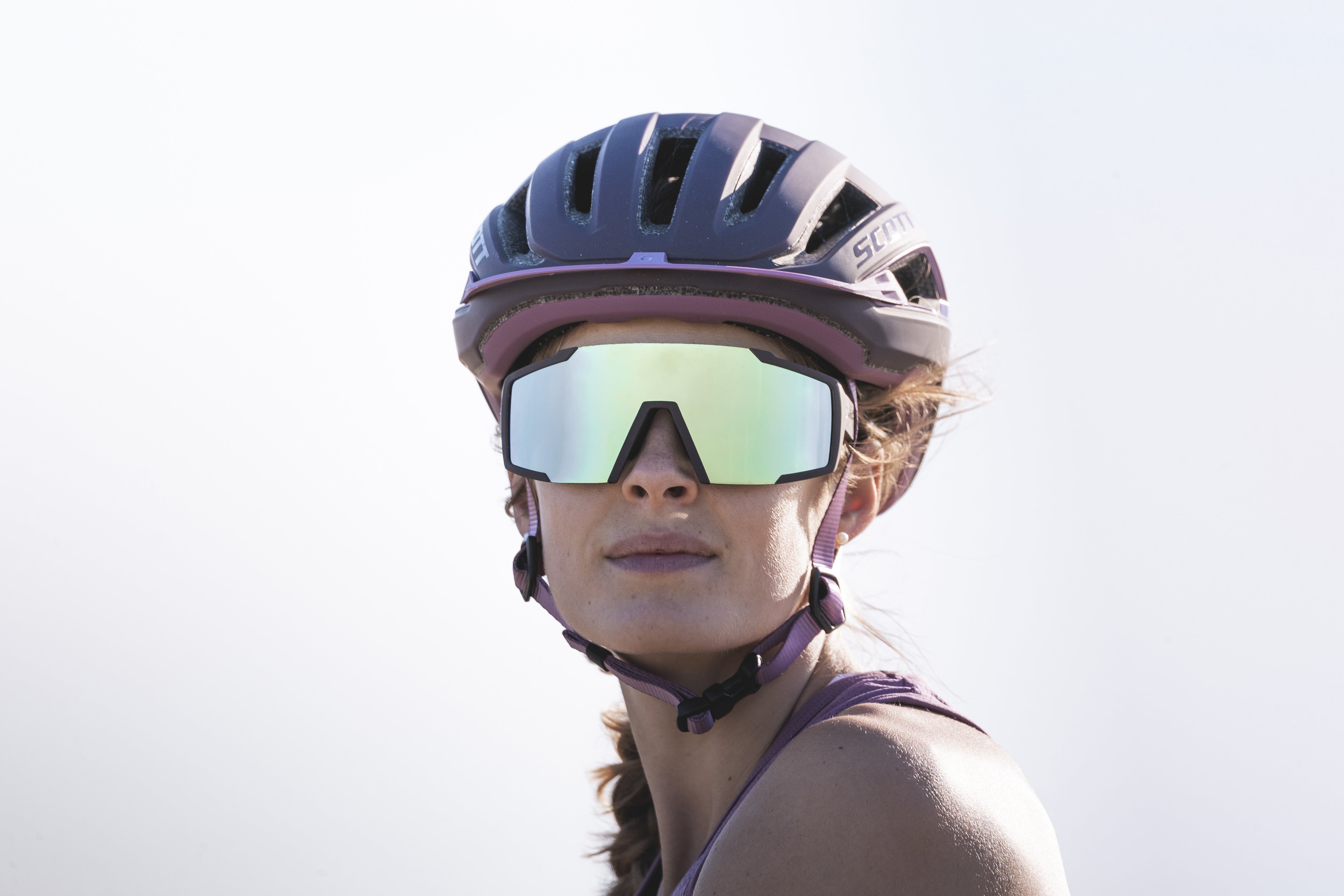 Nainen pyöräilylasit silmillään katsoo kameraan, ja hänellä on päässään myös kypärä