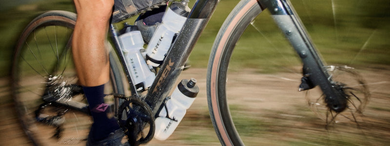 Kuvassa pyöräilijällä on kolme juomapulloa kiinni pyöränsä rungossa