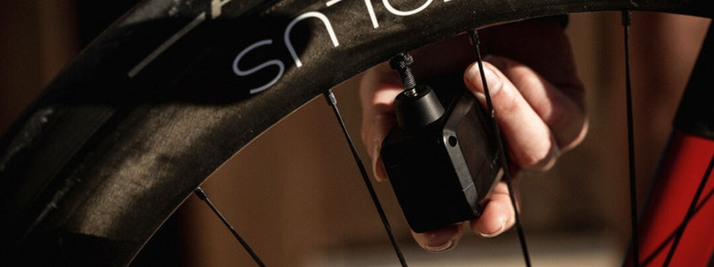 Henkilö täyttää pyörän rengasta pumpulla