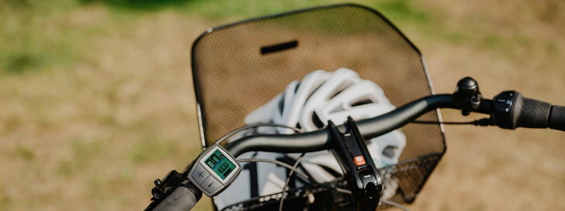 Kuvassa on havainnollistettu pyörän tavarakori edessä, jossa on kypärä